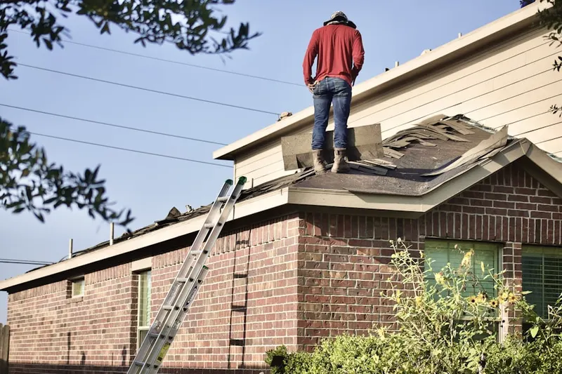 Professional roofer working on a residential roof in Ecru